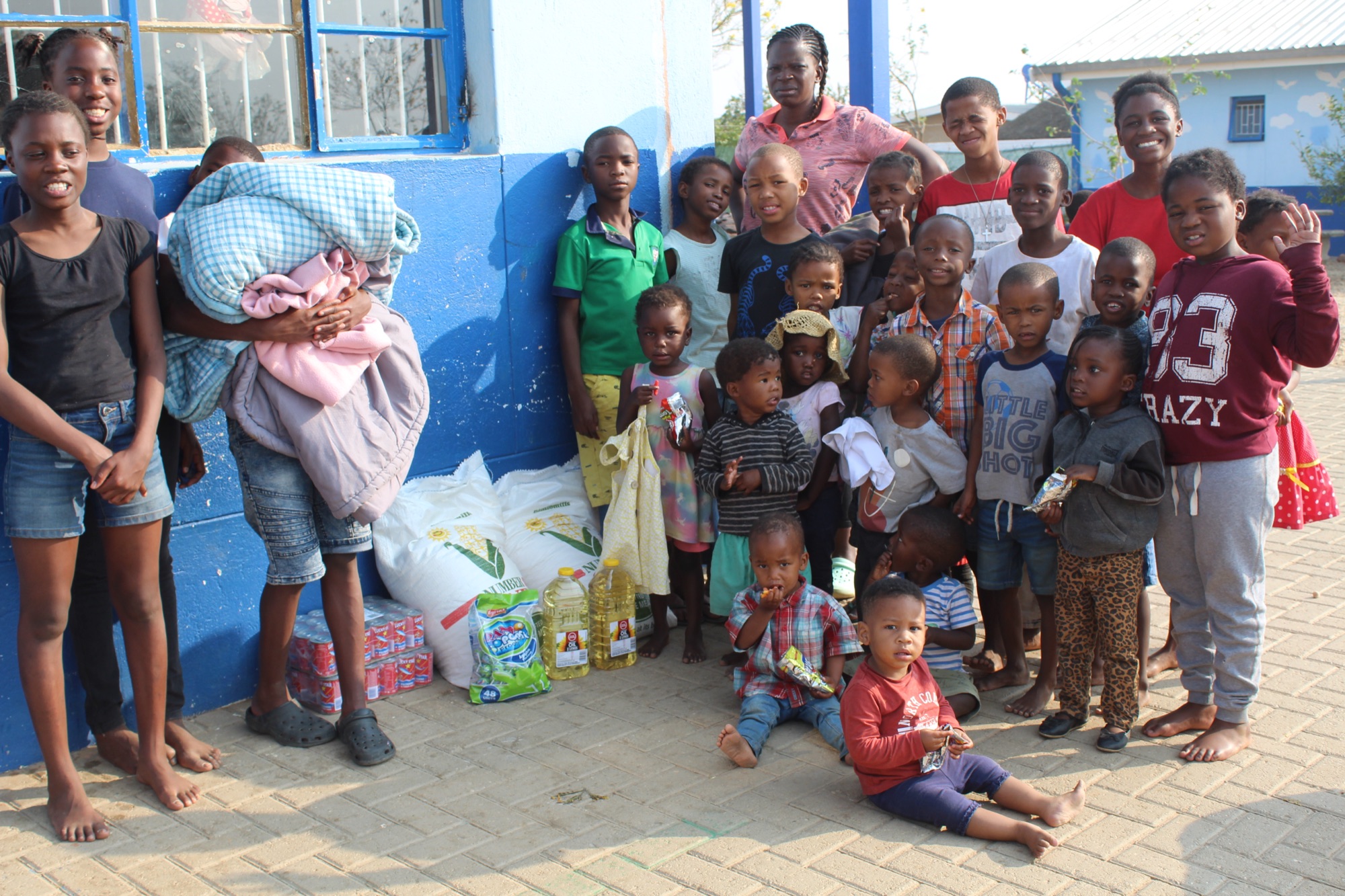 Children gathered beside gifts and essential supplies
